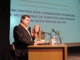 Na foto, à esquerda, Moises Bauer e ao seu lado, Marilu Mourão. Ambos sentados. 